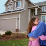 Couple hugging in front of new home